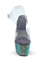 High-heeled shoe with colorful gemstones on a white background