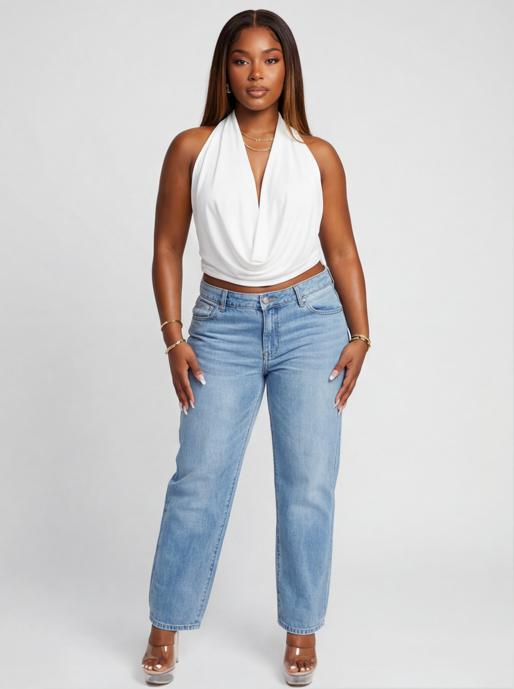 Woman wearing a white halter top and light blue jeans on a white background