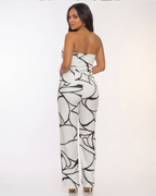 Woman wearing a strapless jumpsuit with black and white abstract pattern in four different poses.