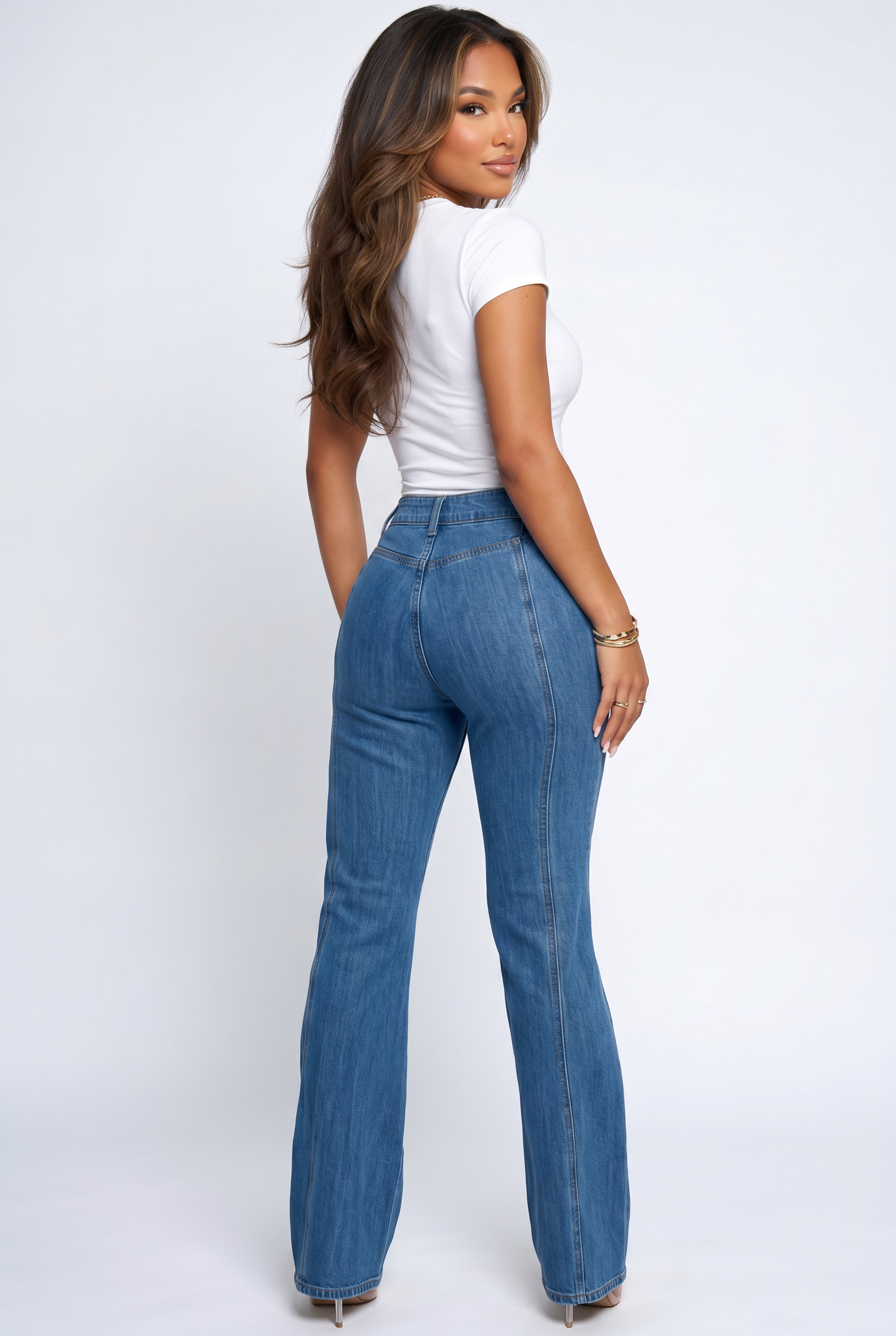 Woman wearing blue jeans and a white top on a white background
