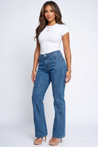 Woman wearing a white top and blue jeans on a white background