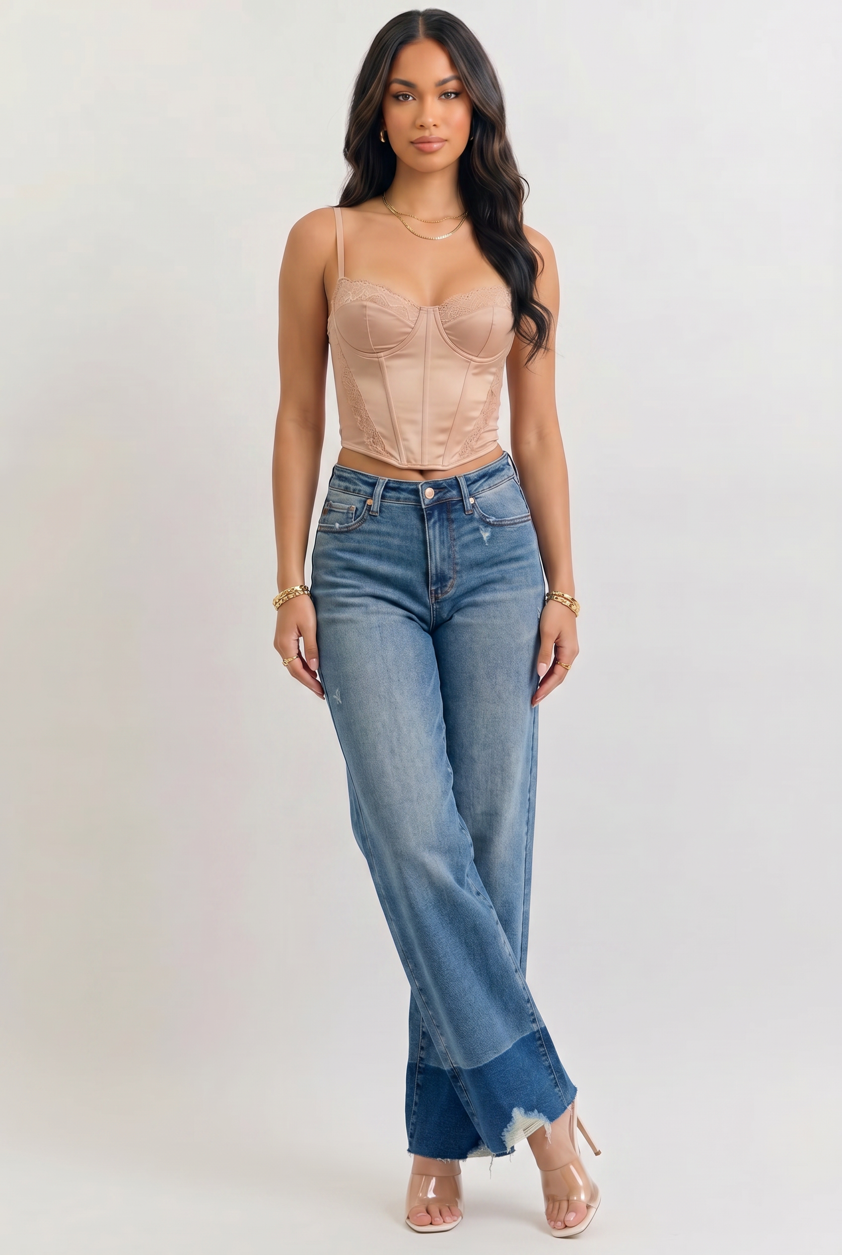 Woman wearing a beige top and blue jeans on a white background