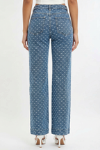 Blue patterned jeans worn by a person on a white background