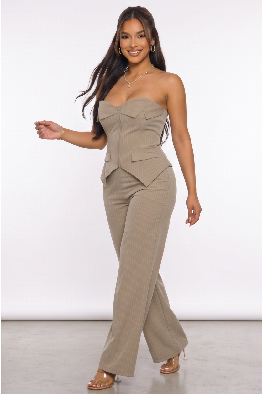 Woman wearing a beige strapless jumpsuit against a white background