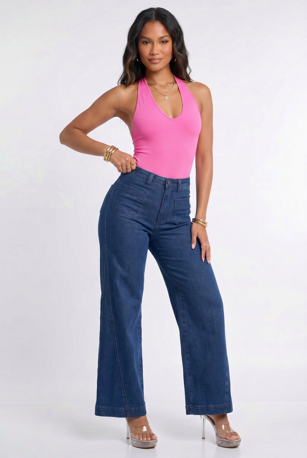 Woman wearing a pink top and blue jeans on a white background
