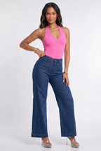 Woman wearing a pink top and blue jeans on a white background
