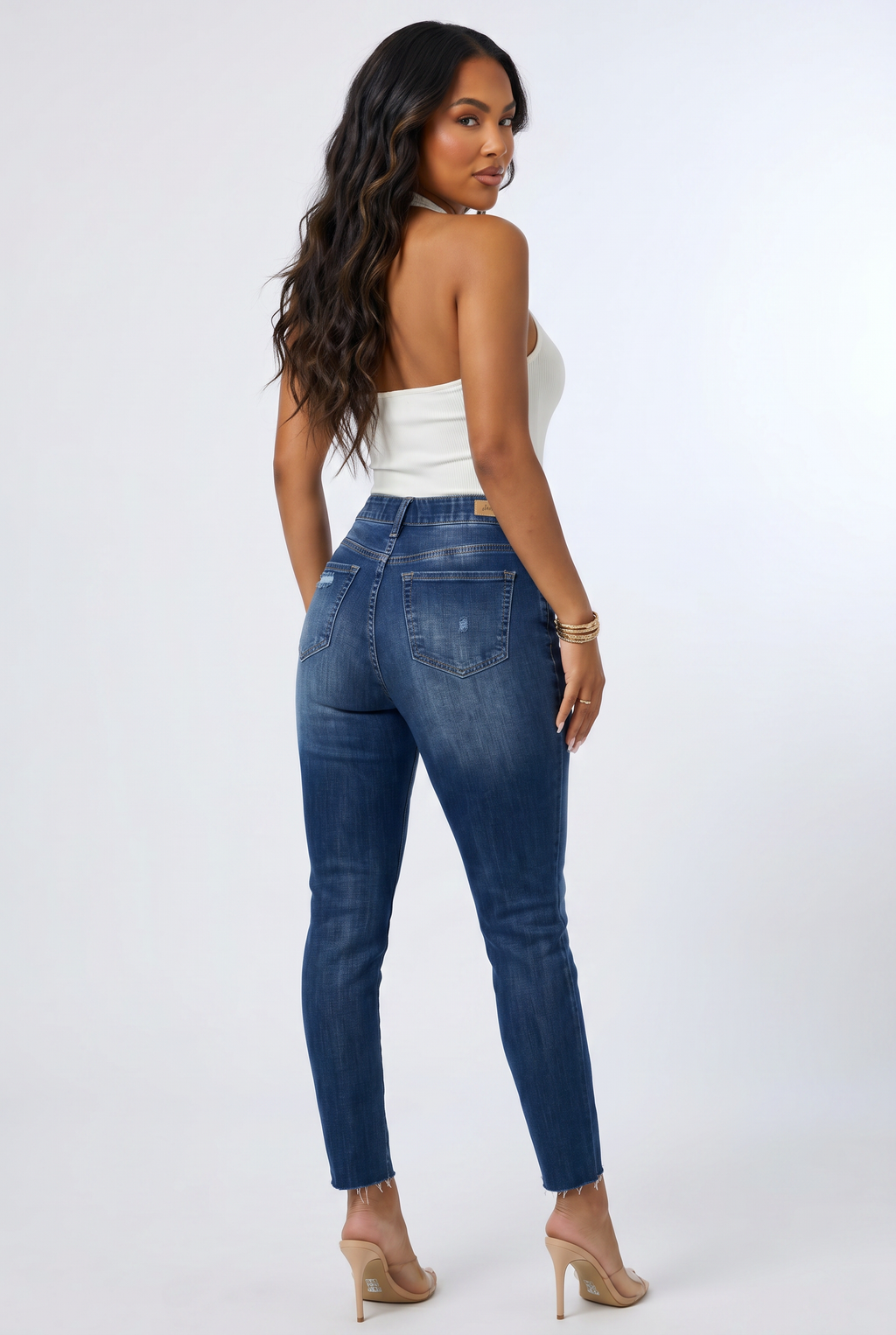 Woman wearing blue jeans and a white top on a white background