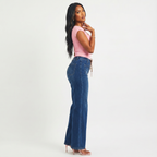 Woman wearing a pink top and blue jeans on a white background