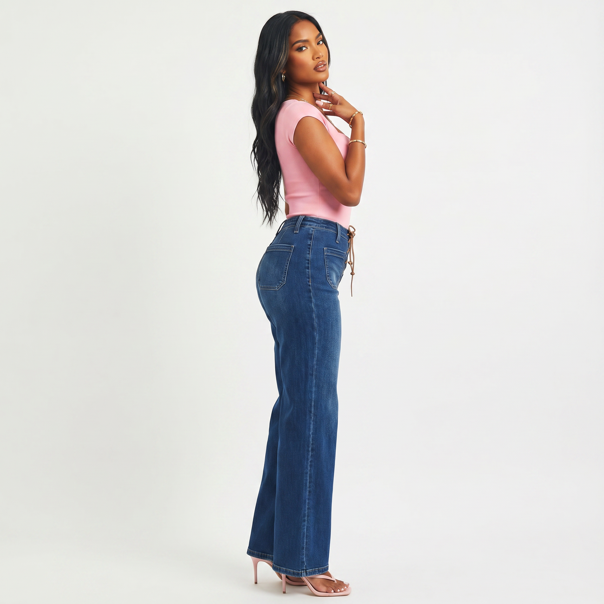 Woman wearing a pink top and blue jeans on a white background