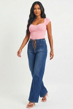 Woman wearing a pink top and blue jeans on a white background