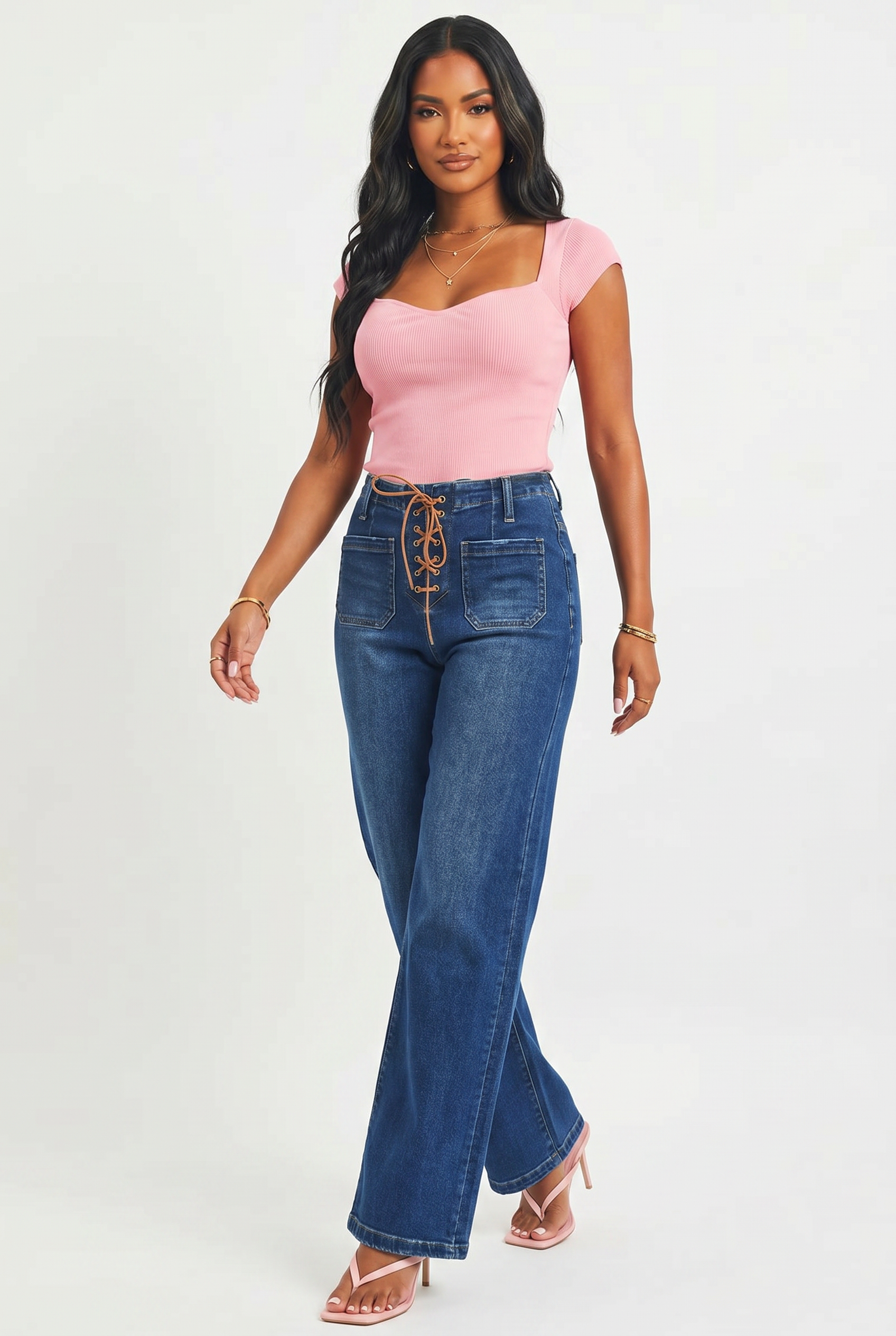Woman wearing a pink top and blue jeans on a white background