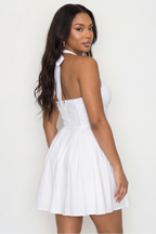 Woman wearing a white dress against a plain background