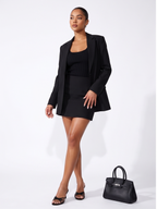 Woman wearing a black suit with a white background