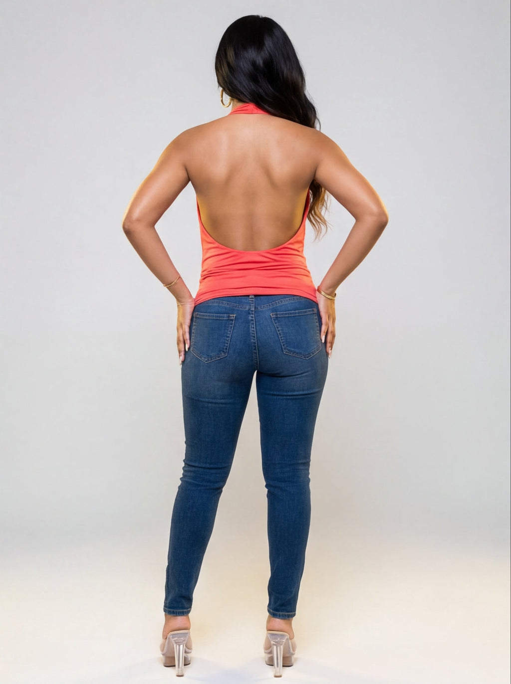 Woman wearing a coral top and blue jeans from different angles on a white background