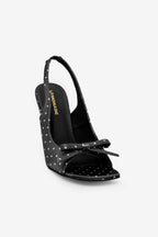 Black studded high-heeled shoe with bow on a white background