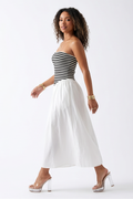 Woman wearing a striped top and white skirt in four different poses on a white background
