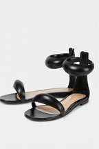 Black sandals worn by a person on a white background