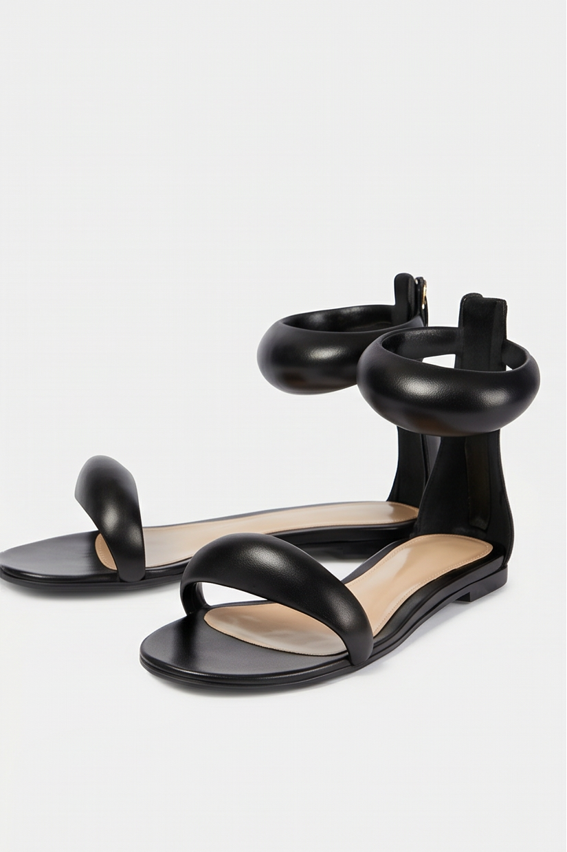 Black sandals worn by a person on a white background