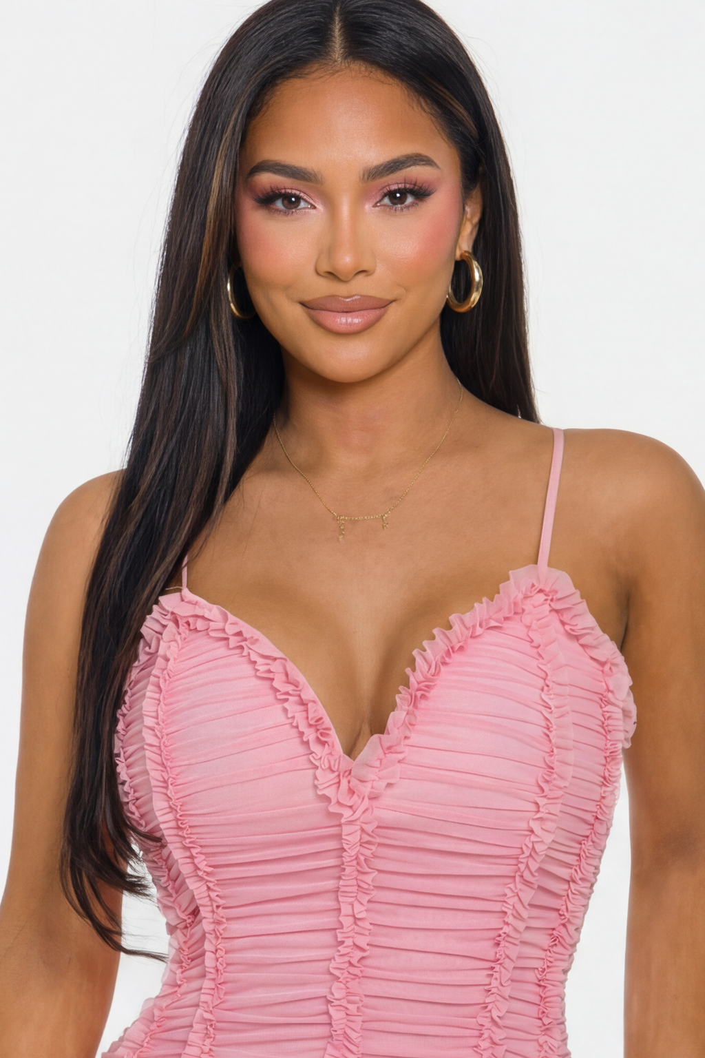 Woman wearing a pink ruched dress against a white background