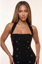 Woman modeling a black dress with star patterns in various poses on a beige background