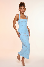 Light blue halter neck dress with star pattern worn by a model on a beige background