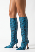 Blue knee-high boots worn by a person on a white background