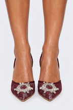 Collage of a woman wearing burgundy high-heeled shoes with decorative elements on a white background.