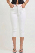 Person wearing white jeans and a black polka dot top on a plain background